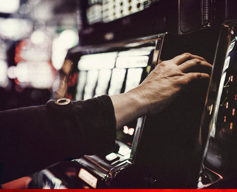 hand pulling the lever on a slot game