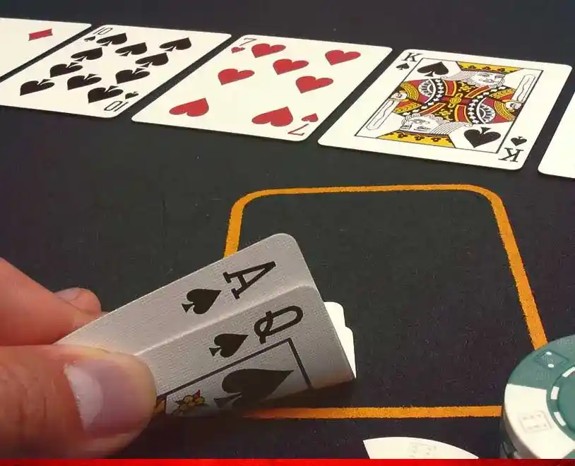 Poker Table and hand holding ace and queen cards